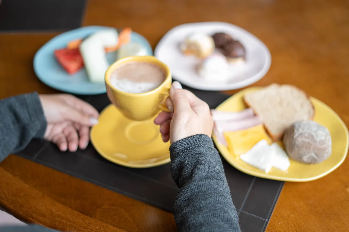 Breakfast at the table, with cappuccino, breads, cold cuts and fruit