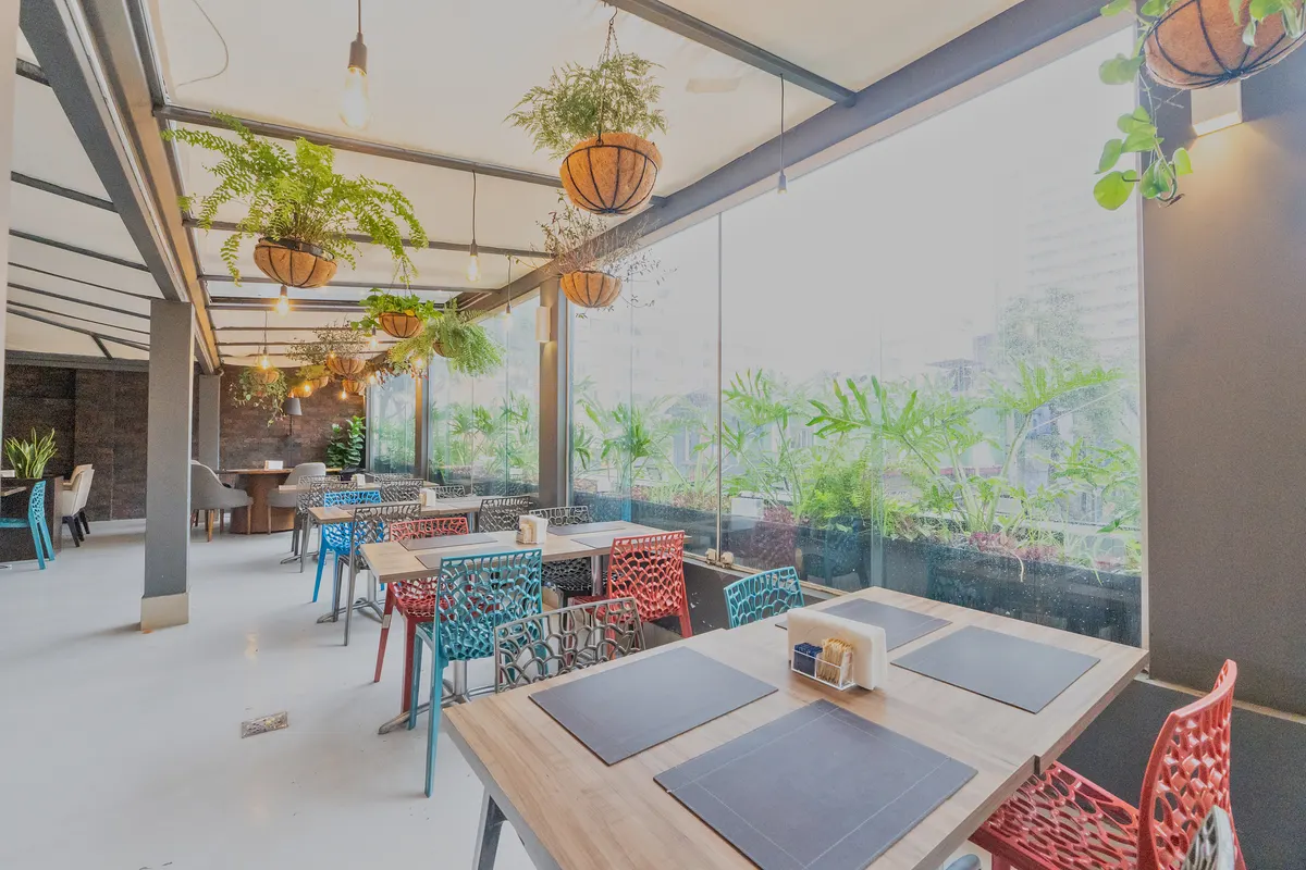 Covered restaurant, with plants and colorful tables